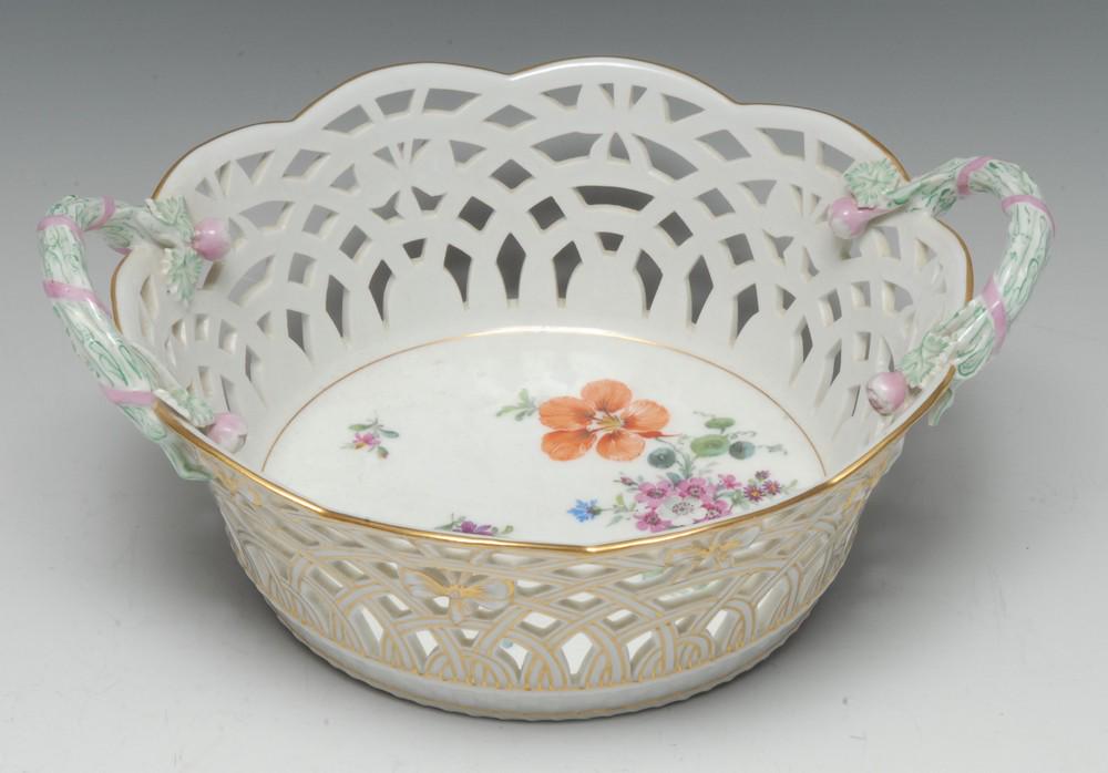 A Berlin two handled basket, painted with flowers,: A Berlin two handled basket, painted with flowers, pierced sides, rustic handles, 23cm diam, KPM mark