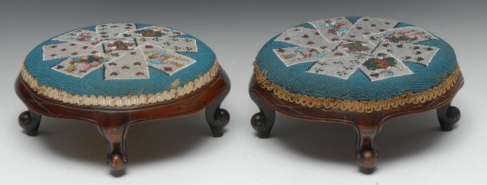 A pair of Victorian mahogany and beadwork shaped: A pair of Victorian mahogany and beadwork shaped circular stools, the tops novelly worked in coloured beads with an arrangement of playing cards on a turquoise ground, scroll aprons, cabriole legs, 29