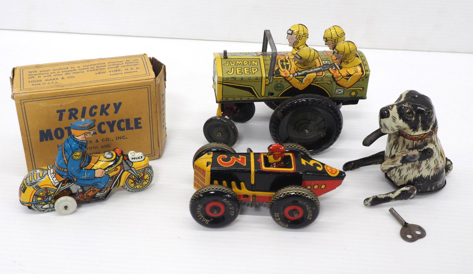 (4) Marx tin litho toys: (4) Marx tin litho toys: Friction Tricky Motorcycle with box -VG, no key, flaps missing on box / Jumping Jeep -works, VG / #5 wind-up race car, 5"L -works / 4"H Flippo wind-up dog -Good, works