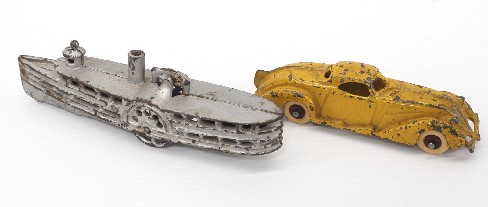 (2) Cast iron toys: (2) Cast iron toys: Hubley Streamline Yellow Coupe, 6"L / Paddle Wheel Boat in Silver, all original, 7½"L -Both Good