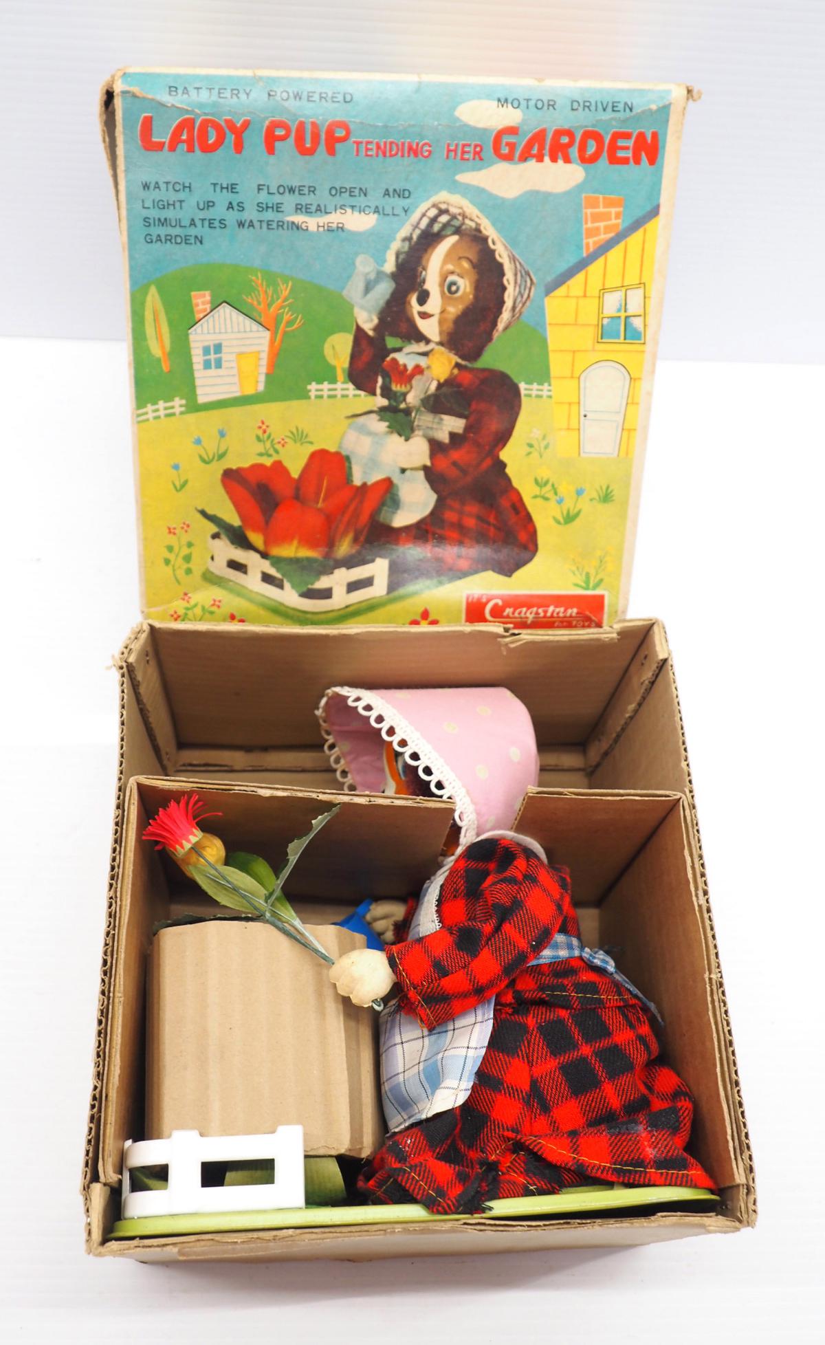 Cragston Lady Pup Tending Her Garden toy: Cragston tin battery-operated Lady Pup Tending Her Garden toy with original box -Very Good, untested