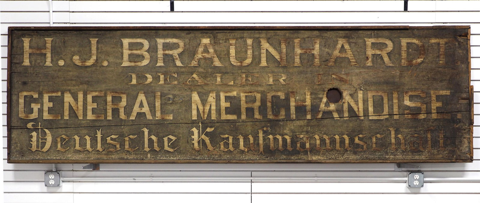 H.J. Braunhardt Dealer General merchandise sign: 10'x3' Wooden H.J. Braunhardt Dealer General merchandise sign, dated on back 1910 Lima, Ohio -Rough -has 4"x4" hole and some wooden trim missing - BUYER TO ARRANGE SHIPPING!