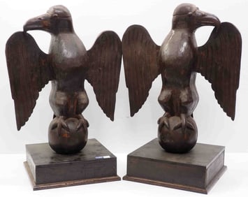 Pair of carved wooden facing eagles on globes