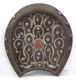 Horseshoe-shaped shadow box with horseshoes