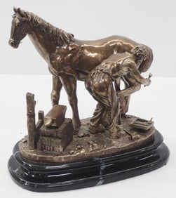Bronze statue of blacksmith shoeing a horse