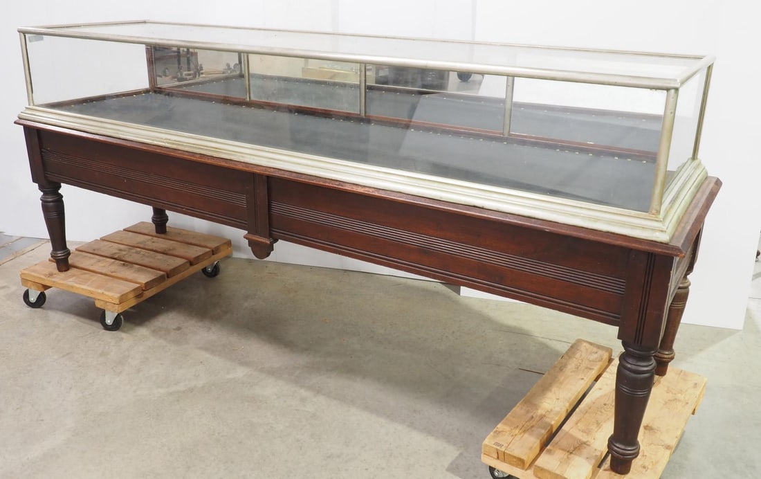 8.5-foot long country store display case: 8.5-foot long country store display case with nickel plating and fold-down mirrored back doors, base has turned legs and 2 drawers in back, 102"x29"x42"H overall * * Not eligible for in-house shipping