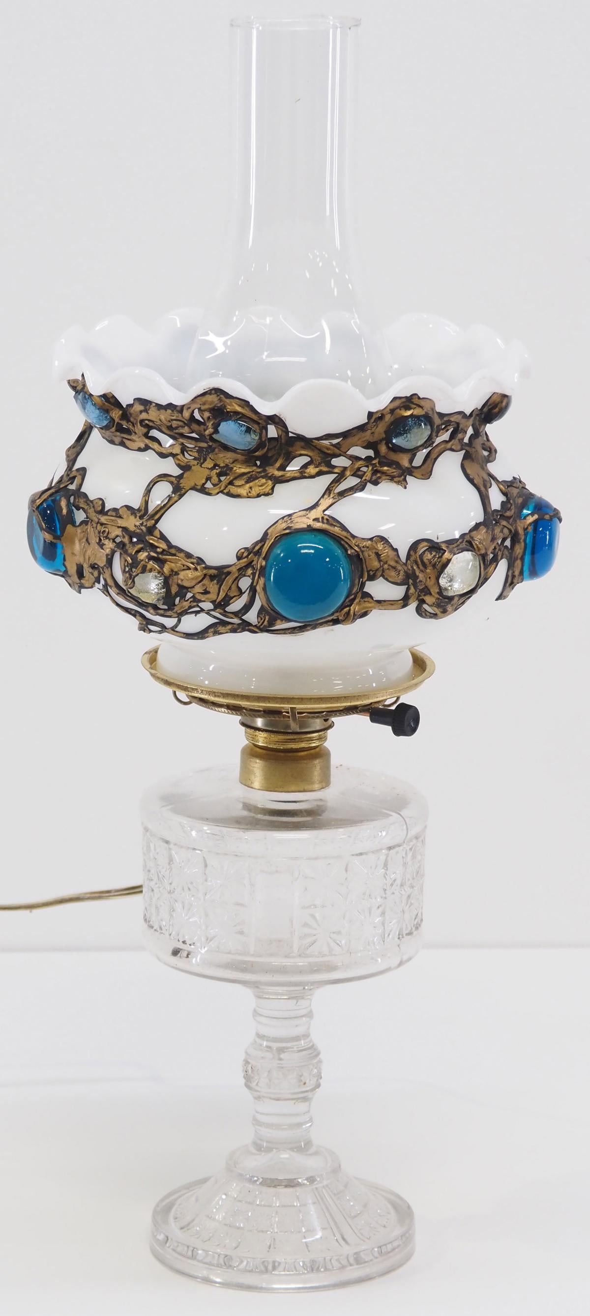 Clear EAPG Electrified Oil Lamp: Clear EAPG Electrified Oil Lamp with Milk Glass Shade and Applied Jewels Condition NOTICE! VERY IMPORTANT! Chupp Auctions is pleased to issue an opinion on any lot; the absence of a condition report