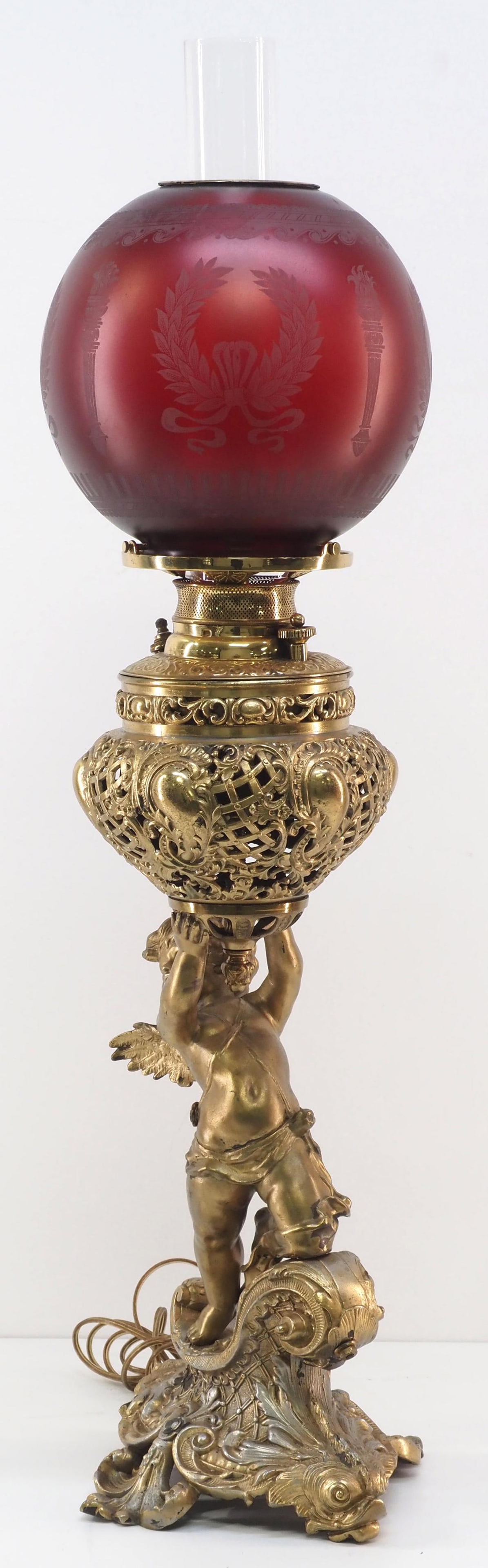 19th Century Victorian Polished Brass Banquet Lamp: 19th Century Victorian Polished Brass Banquet Lamp with Cast Brass Cherub Base and Frosted Etched Satin Oxblood Red Globe Condition NOTICE! VERY IMPORTANT! Chupp Auctions is pleased to issue an opinio