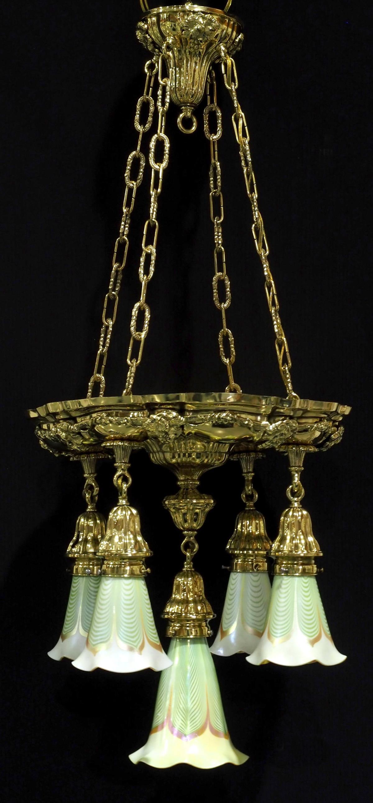 Elaborate Hanging Fixture with 5 Gold Aurene Art Glass Shades: Elaborate Cast & Pressed Polished Brass Hanging Fixture with 5 Gold Aurene Pulled Feather Art Glass Shades Condition NOTICE! VERY IMPORTANT! Chupp Auctions is pleased to issue an opinion on any lot; t