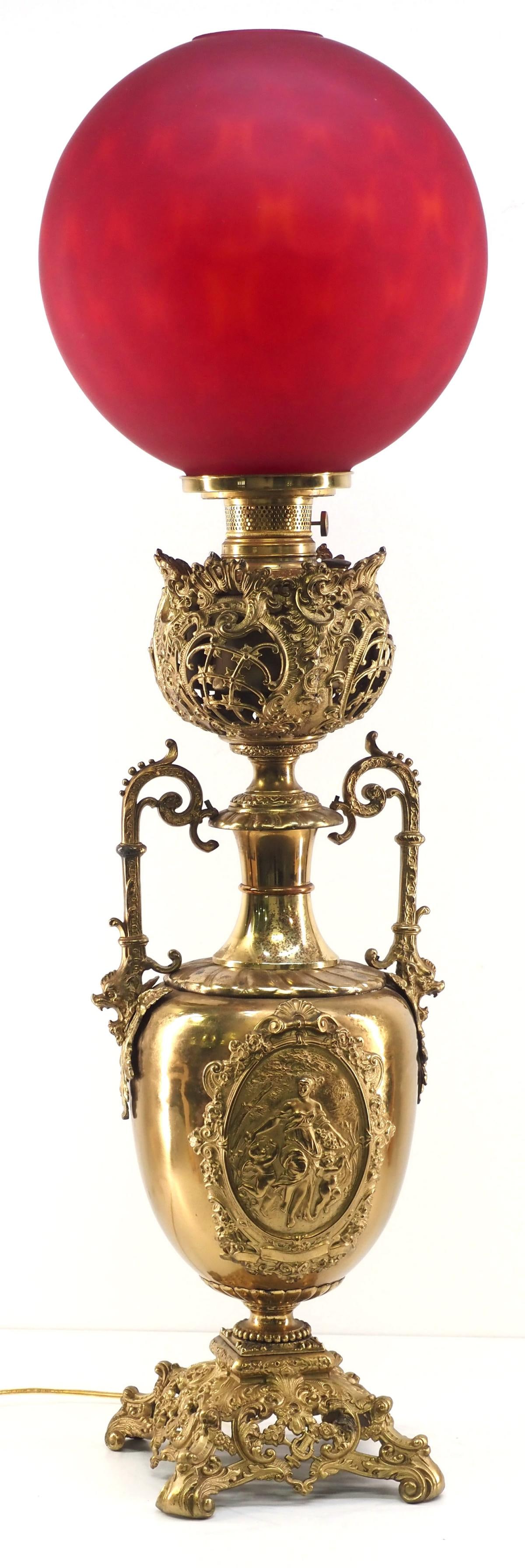 Monumental Art Nouveau-style Banquet Lamp with Oversized Burgundy Satin Globe: Monumental Art Nouveau-style Banquet Lamp with Decorated Brass Base and Oversized Burgundy Satin Glass Globe Condition NOTICE! VERY IMPORTANT! Chupp Auctions is pleased to issue an opinion on any lot;