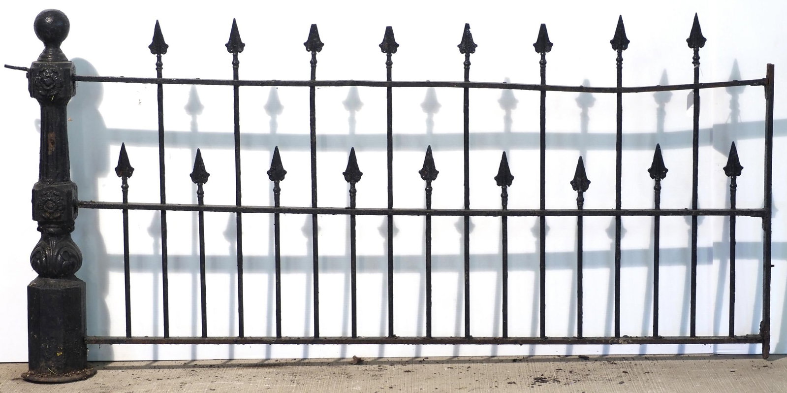 Section of cast iron fence with ornate post: Section of cast iron fence with ornate post, 76"L and 38"H post - base has chips * * NOT ELIGIBLE FOR IN-HOUSE SHIPPING. Please contact the auction house for transport options and additional details.