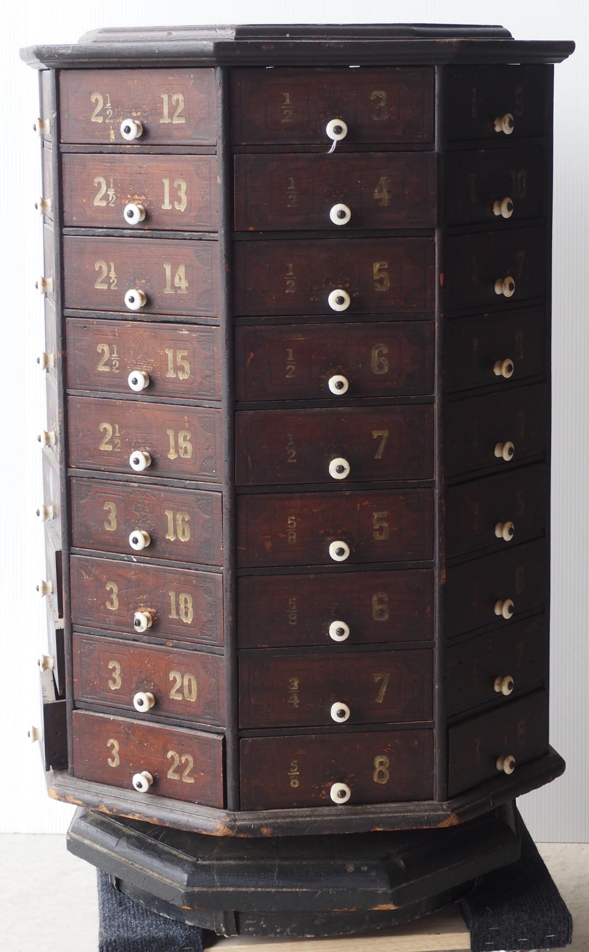Revolving country store 72-drawer bolt cabinet: Wooden octagon revolving country store 72-drawer bolt cabinet with porcelain knobs, 32"H * * NOT ELIGIBLE FOR IN-HOUSE SHIPPING. Please contact the auction house for transport options and additional