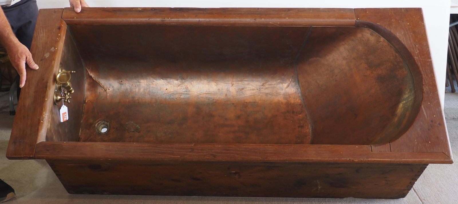 Copper bathtub: Copper bathtub with dovetailed wood frame, 65"L x 28"W x 21"H - 3" gash in bottom * * NOT ELIGIBLE FOR IN-HOUSE SHIPPING. Please contact the auction house for transport options and additional