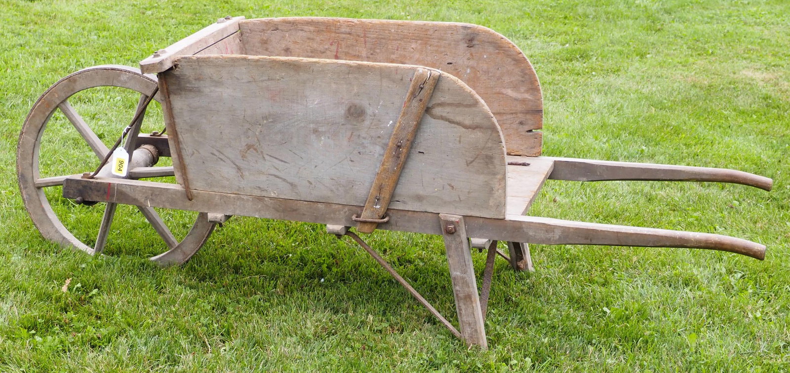 Primitive wooden wheel wheelbarrow: Primitive wooden wheel wheelbarrow, 6'L overall, 22"dia. wheel - runner repaired * * NOT ELIGIBLE FOR IN-HOUSE SHIPPING. Please contact the auction house for transport options and additional details. 
