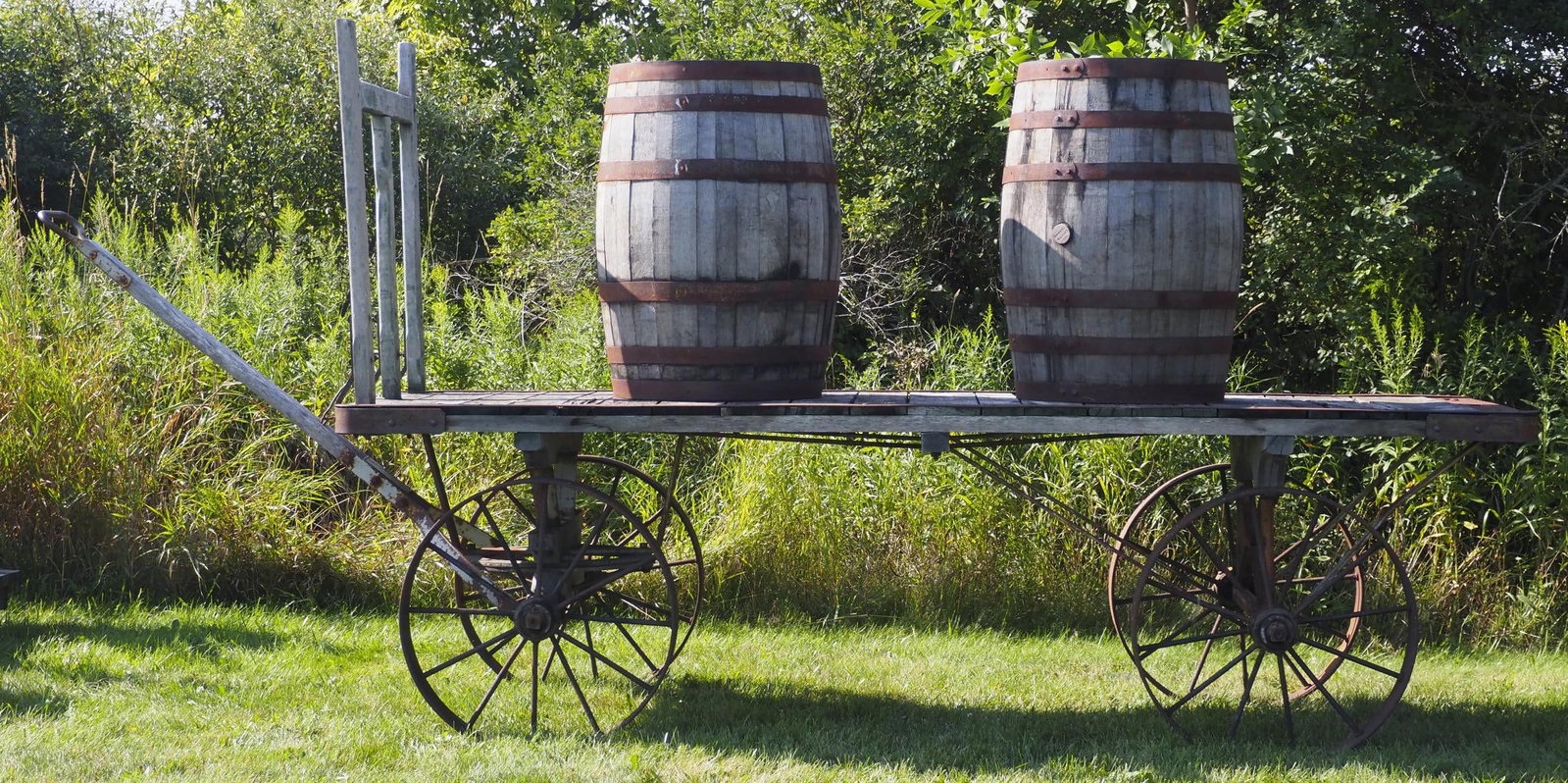 Railroad luggage wagon with Lansing Company tag: Railroad luggage wagon with Lansing Company tag and (2) wooden barrels (Yellowstone & Jack Daniels Whiskey), 10'L overall * * NOT ELIGIBLE FOR IN-HOUSE SHIPPING. Please contact the auction house