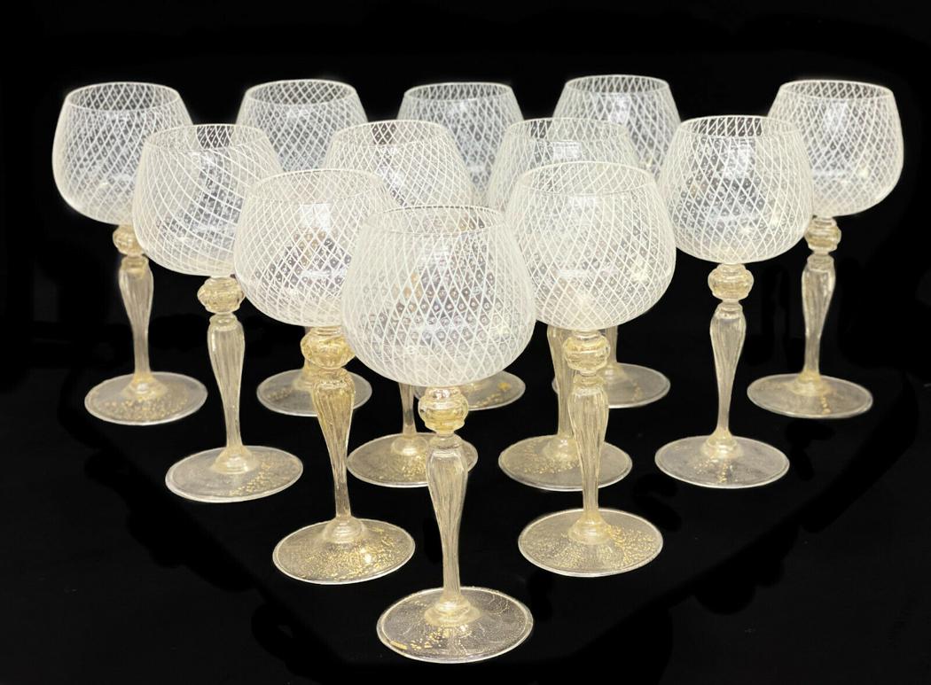12 Venetian White Latticino Striped Wine Goblets: 12 Venetian white latticino striped wine goblets, circa 1960. White latticino stripes to the bowls of the goblets. Gold fleck to the bulbous stems and bases. Weight Approx., 3 lbs Measures Approx., 3.