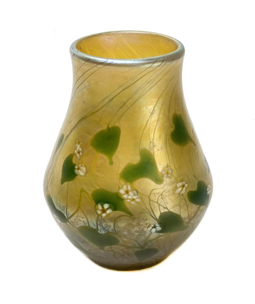 Louis Comfort Tiffany Millefiori Favrile Glass Vase: A fine LCT art glass vase with gold iridescence vase with heart and vine design with millefiore flowers. Signed L.C.T. to rim of base and numbered 05755 on the polished pontil. Circa 1900. Weight Appr