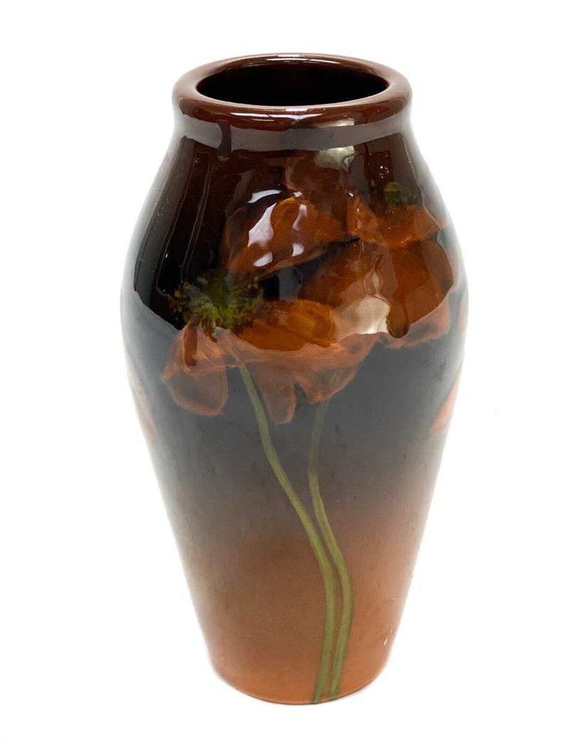 Rookwood Pottery Amber Floral Vase #925E by Henry Moos: Rookwood pottery amber floral vase #925E by Henry Moos. A brown to orange amber ground with hand painted delicate orange flowers to the central area. Rookwood mark to the underside- possibly by the ar