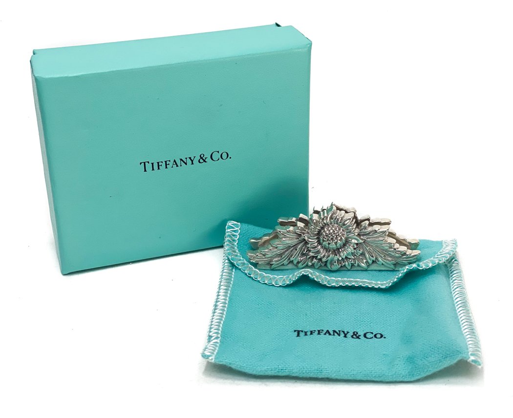 Tiffany & Co. Sterling Silver Place Card Holder in: Tiffany & Co. Sterling Silver Place Card Holder in Chrysanthemum. Hand chased chrysanthemum flowers. Marked Tiffany & Co. to the underside. With dust bag and box. Weight Approx., 1.41 ozt Measues Appr