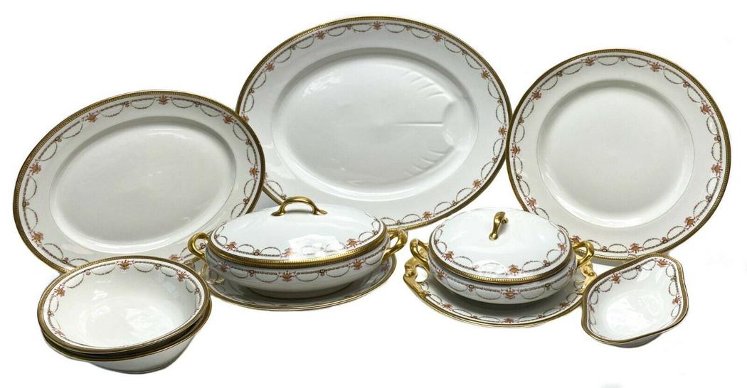 10 pc Bernardaud Limoges Porcelain Serving Set with: 10 pc Bernardaud Limoges Porcelain Gilt Rimmed Serving Set with Floral Swags c1910. This service includes: - Large oval meat serving platter - Large round serving platter - Large oval serving platter