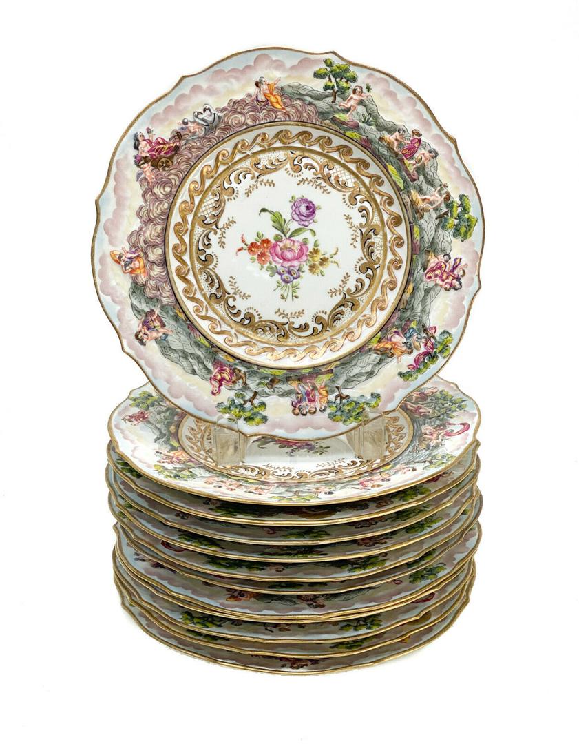 12 Capodimonte Porcelain Hand Painted 9 inch Plates: 12 Capodimonte porcelain hand painted 9 inch plates. Raised figures around the rim of the plates with floral bouquets to the center. Capodimonte mark to the underside base. Weight Approx., 12 lbs Meas