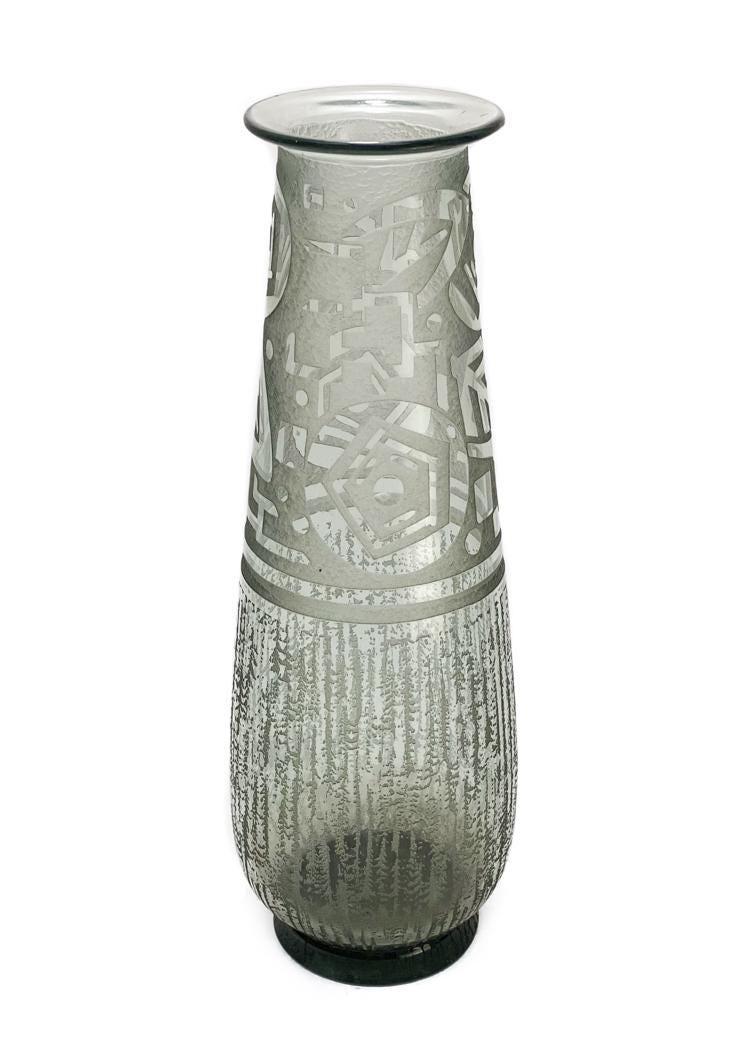 Daum Nancy Engraved Vase: An acid etched and engraved clear and grey vase by Daum Nancy, France with geometric designs to the upper half. Circa 1935. With wheel engraved Daum signature to edge of base with Cross of Lorraine. W