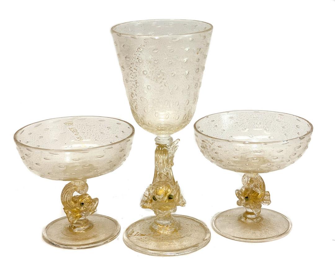 3 Salviati Amber Controlled Bubble Glass Wine Goblets: 3 Salviati amber yellow art glass champagne and wine glass goblets, circa 1950. Controlled bubbles to the bowls of the glasses. Gold fleck dolphins to the handles of the stems. There are 2 champagne s