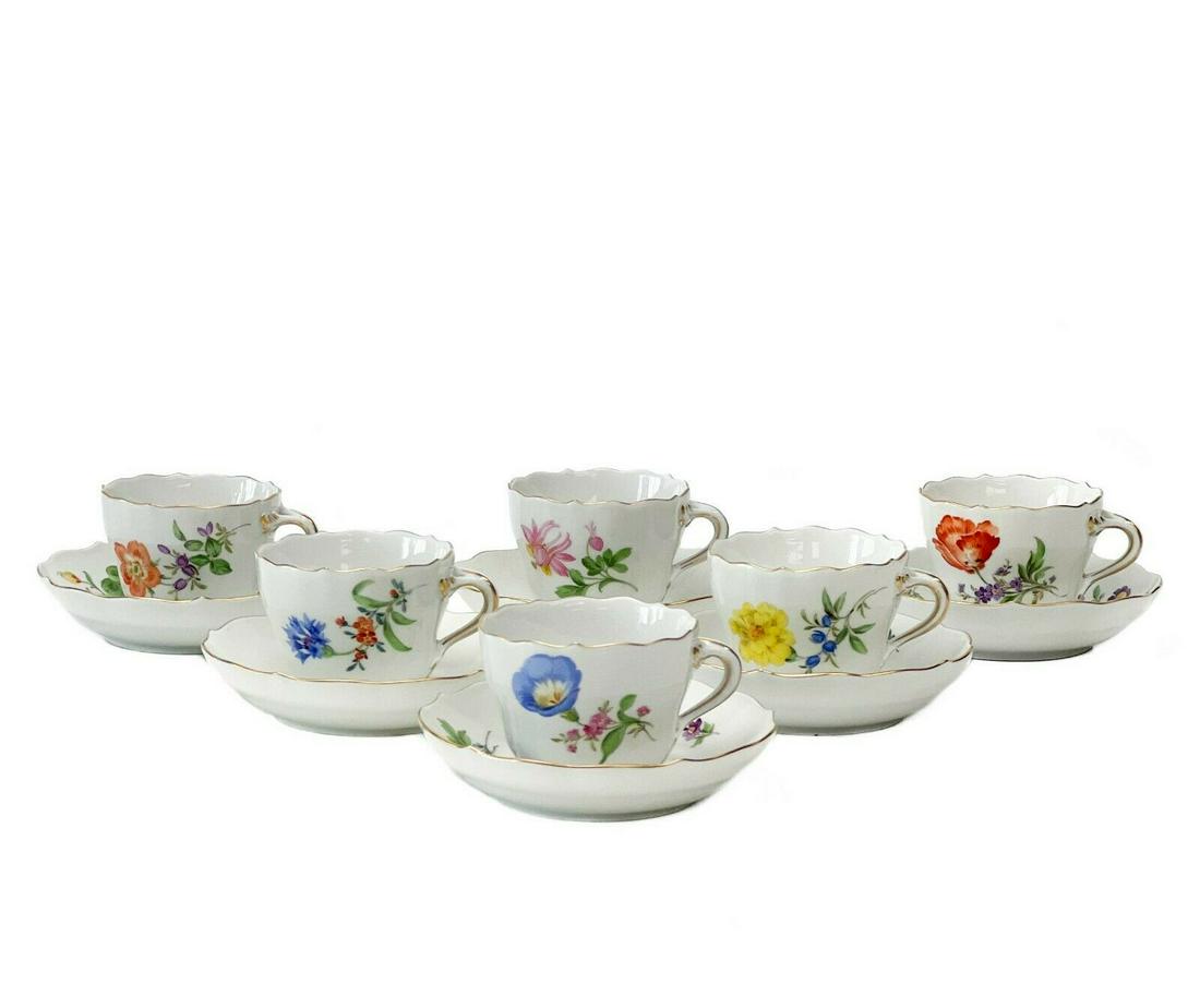6 Meissen Porcelain Demitasse Cups & Saucers Florals: 6 Meissen Germany hand painted floral demitasse cups & saucers. A white ground with various colorful floral decoration, gilt to the scalloped rim. Meissen crossed swords mark to the underside. Each wi