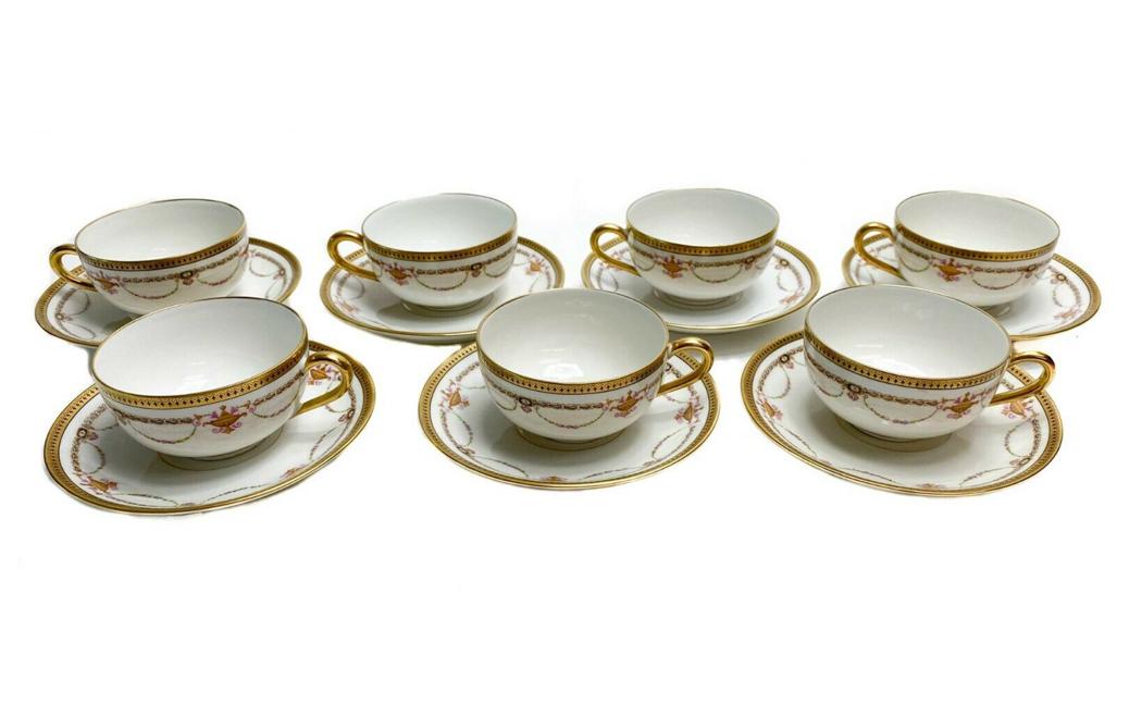 7 Bernardaud Limoges Porcelain Cups & Saucers with Floral Swags: 7 Bernardaud Limoges Porcelain Gilt Tea Cups & Saucers with Floral Swags c1910. Gilt design around rim and floral swag decorations throughout. Weight Approx., 3.5 lbs Measures Approx., Tea cup: 4.5 in