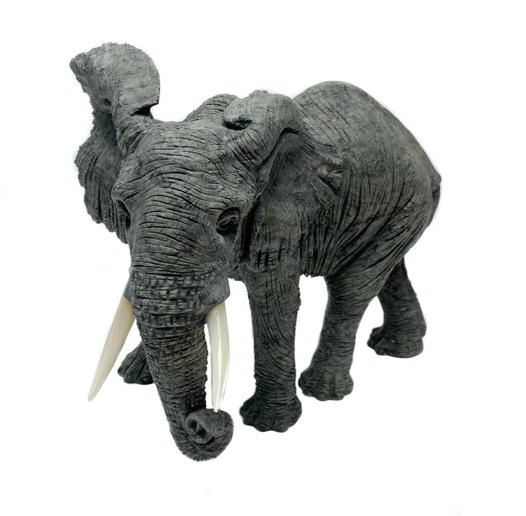 Fine Carved Gray Jasper Sculpture of an Elephant: The gray jasper elephant sculpture is realistically modeled with a finely engraved body and mother of pearl tusks. Weight Approx., 7.6 lbs Measures Approx., 9.4 in. x 5 in. x 7.6 in. tall.Domestic Shi