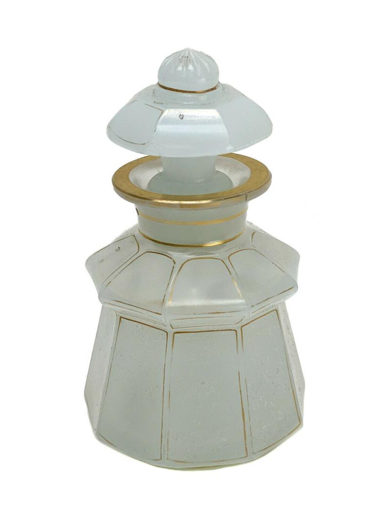 French White Opaline Glass and Gilt Perfume Bottle: French White Opaline glass and gilt lidded perfume bottle. Multi-lobed walls with gilt accents. Weight Approx., 1.5 lbs Measures approx., 3.5 inches diameter x 6 inches tall.Domestic Shipping: $40