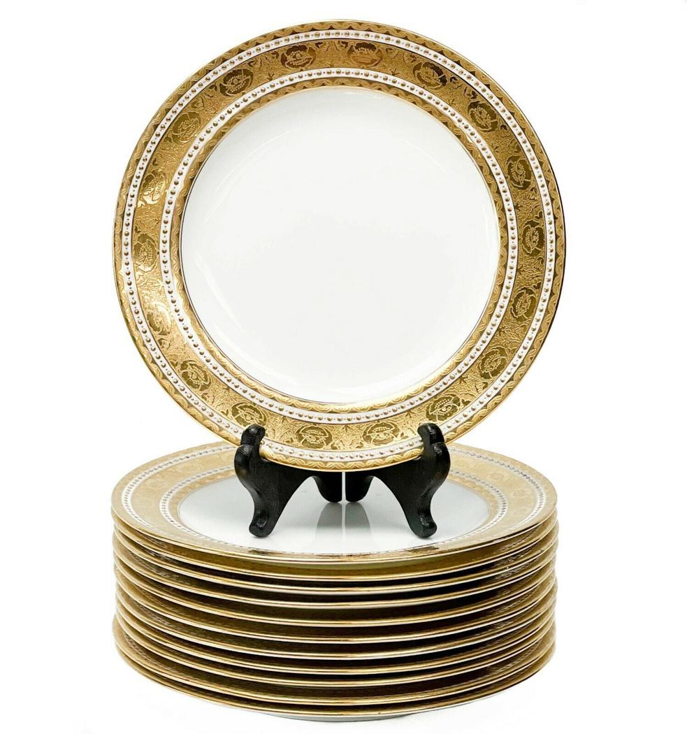 12 Minton England Gilt Porcelain 7.75 inch Dessert Plates in H1417, 1910: 12 Minton England gilt porcelain dessert plates in H1417, 1910. A white ground to the center, ornate gilt decoration to the edge featuring florals and twisted ribbons. Bands of raised gilt dot decorat