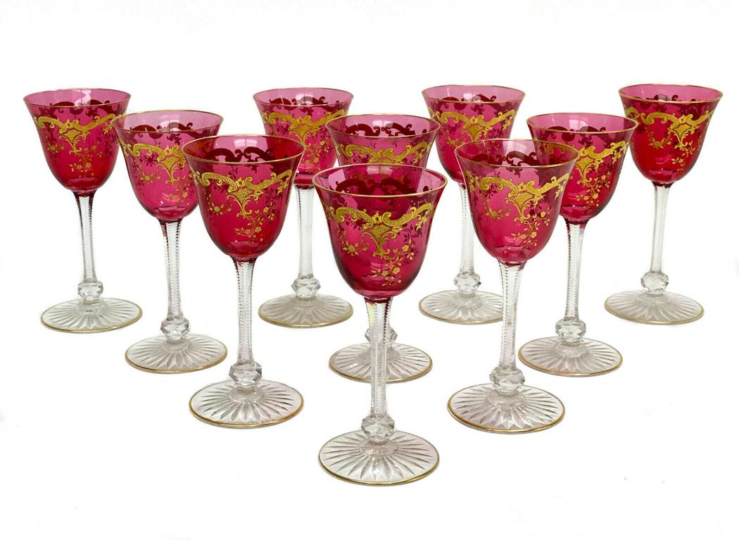 10 Saint Louis Massenet Cranberry Red Wine Goblets: 10 St Louis Massenet cranberry red gold encrusted glass wine goblets. Gold encrusted foliate and floral design with gilt accents, cut glass knobbed stem, and a star cut foot. Weight Approx., 2 lbs Mea