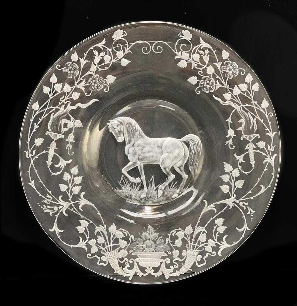Steuben Engraved Stallion Plate: A Steuben engraved plate depicting a horse frolicking in grass, surrounded by flowers and vines to the border. Signed Steuben to the underside. With leather bound presentation box. Likely mid century.