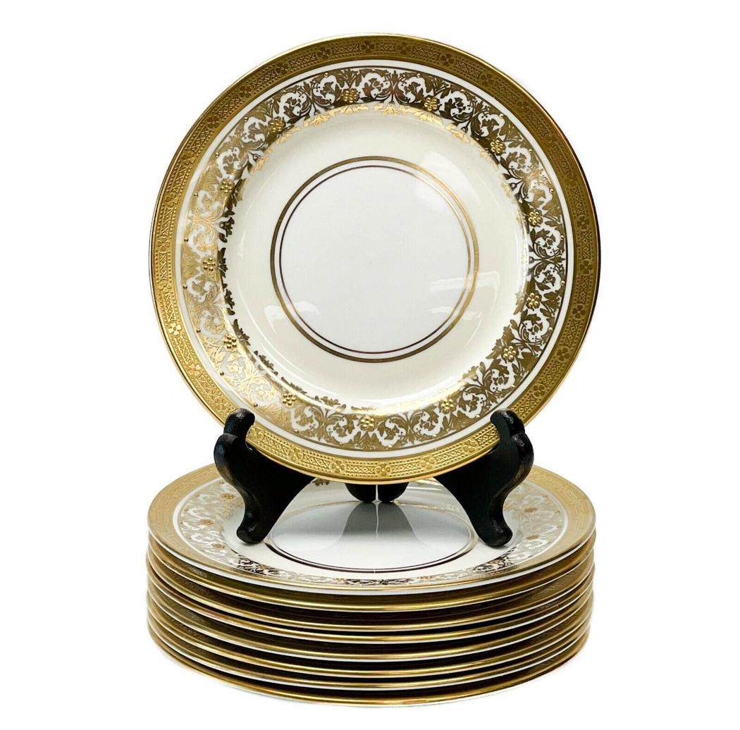 9 Aynsley England Porcelain Bread Plates in Kenilworth Ivory Raised Gold c.1940: 9 Aynsley England porcelain bread plates in Kenilworth Ivory, circa 1940. A white center with an off-white ground to the edge with ornate gilt foliate decoration with raised gold floral accents. A geo
