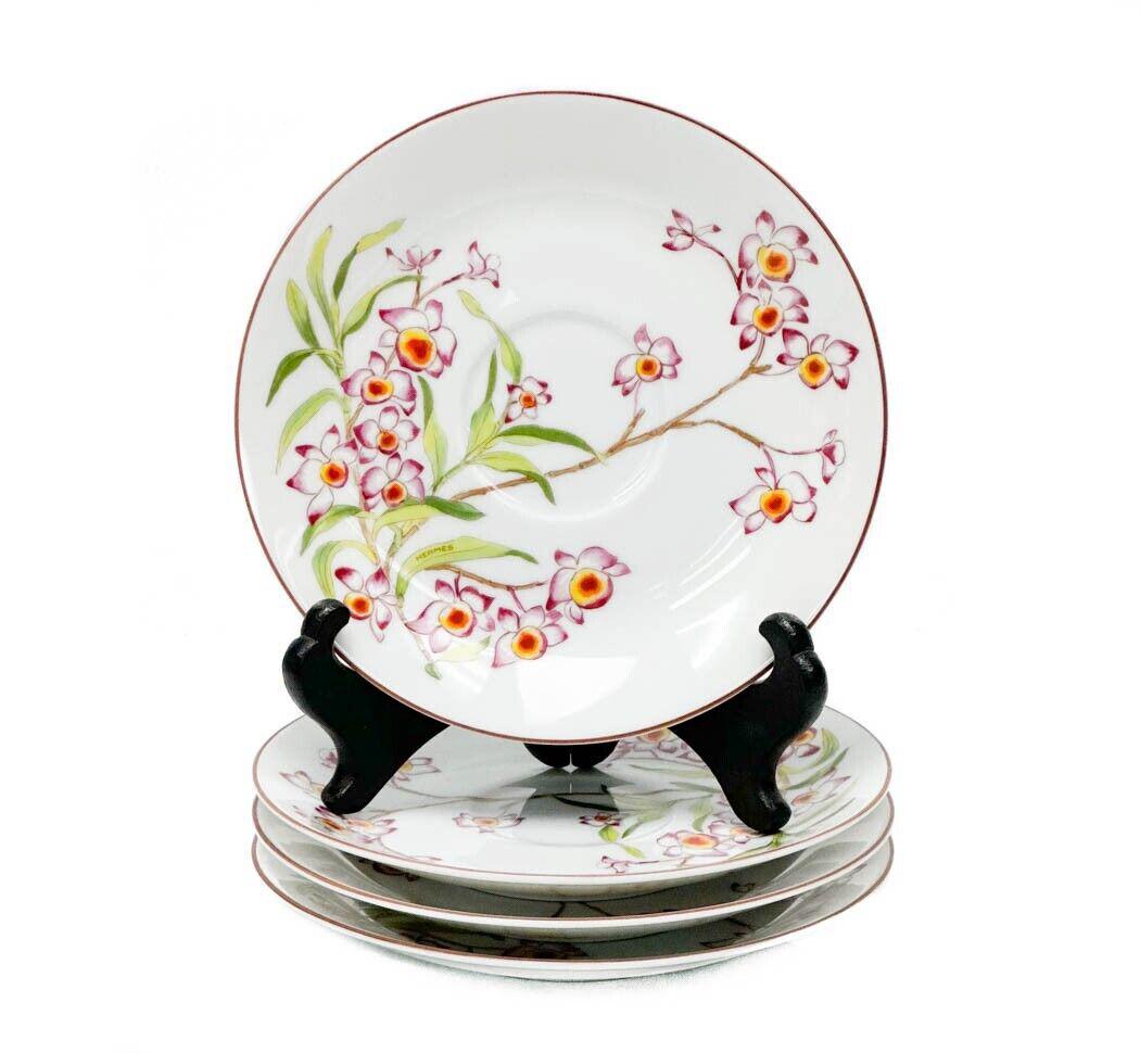 4 Hermes France Porcelain 5.8 inch Saucers in Jardin des Orchidees: 4 Hermes France Porcelain Saucers in Jardin des Orchidees. A white ground with purple, orange, and white orchid plants. Underside marked Hermes Paris Jardin des Orchidees dendrobium nobile. Weight App