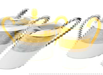 2pc Christofle France Gilt & Platinum Banded Porcelain Cream & Sugar in La Paiva: Christofle France porcelain creamer and lidded sugar bowl in La Pavia. A white ground to center, gilt to the edge and with platinum bands to the rim with floral designs. Gilt to rims and handles. Unde