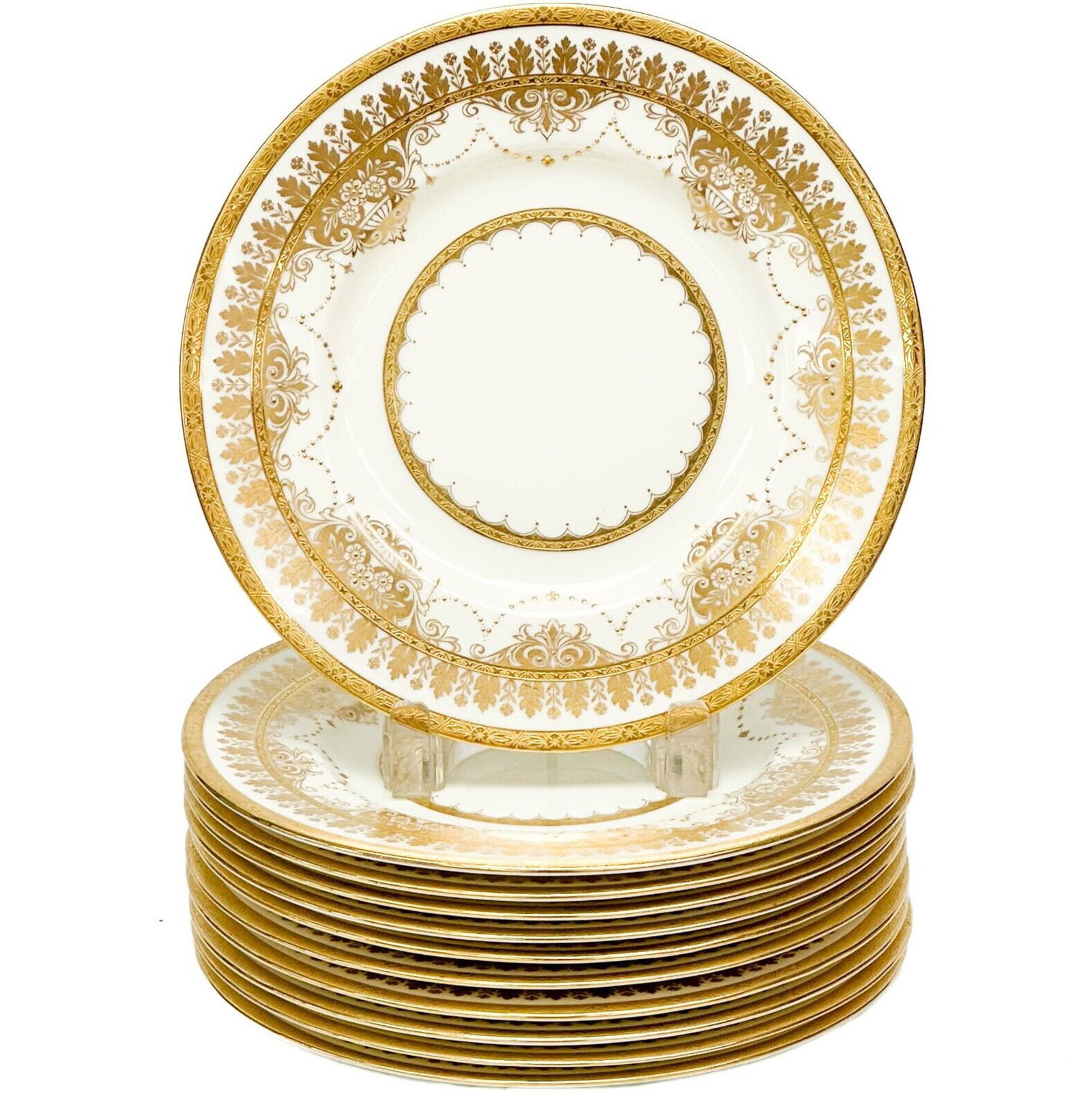 11 Minton England for Collamore Gilt Porcelain Dessert Plates 1927 / 1929: 11 Minton England porcelain dessert plates. Cream colored plates with gilt garland and floral decoration. Underside with Minton marks, Collamore retailer's marks. Minton impressed date codes for 1927 