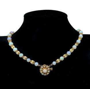 14k Yellow Gold and Opal Graduated Beaded Necklace: 14k Yellow Gold and Opal Graduated Beaded Necklace. Opal round beads measuring 6.2mm to 13.4mm with alternating ribbed gold spacers. Floral clasp marked 14k to clasp. Weight Approx., 46.29 grams Measu