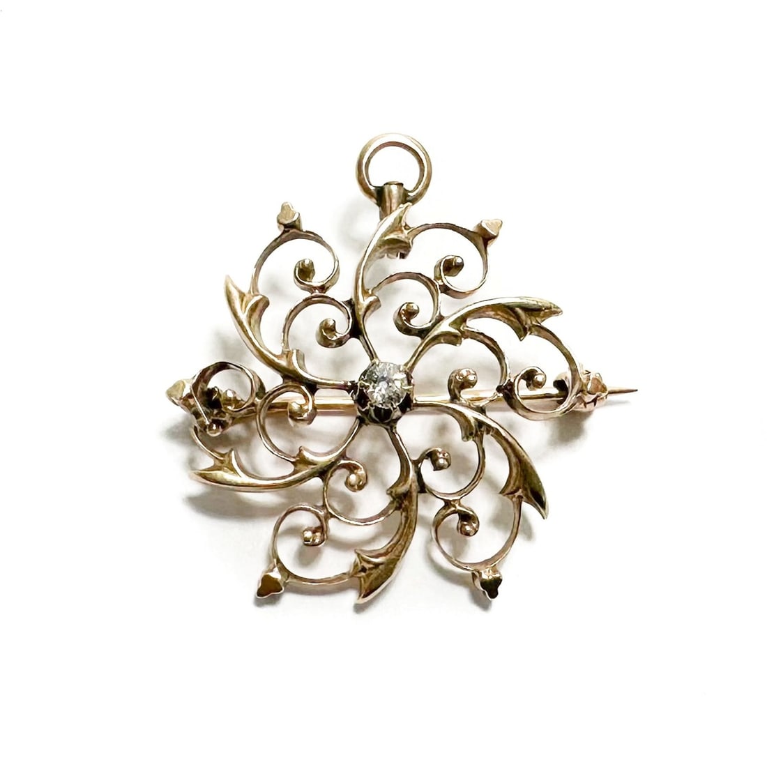 10k Yellow Gold and Diamond Filigree Brooch Pin: 10k Yellow Gold and Diamond Filigree Brooch Pin. Openwork swirls to the face with a diamond center. Marked "10k" to backing. Weight Approx., 3.5g Measures Approx., 1 inches diameter