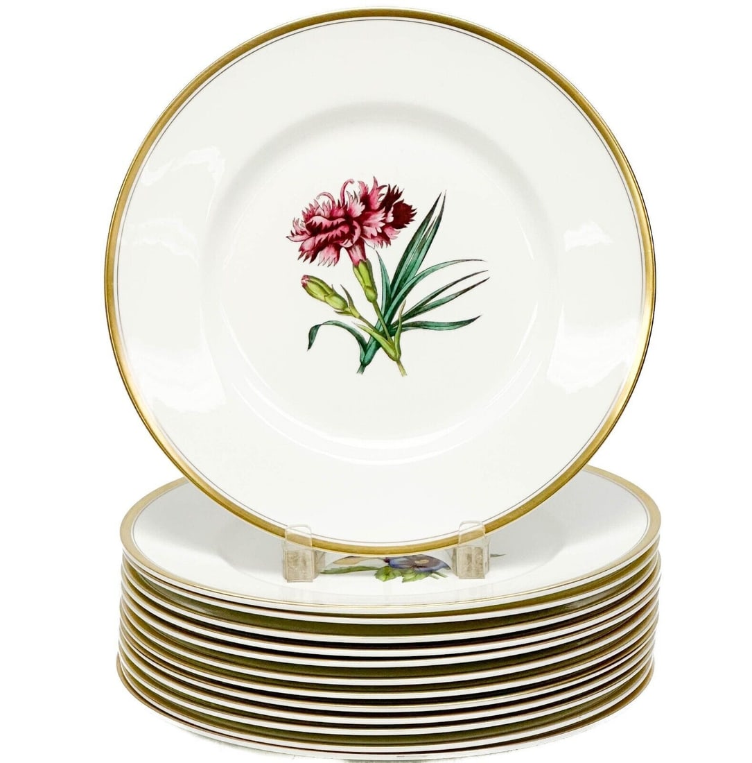 12 + 1 (13) Royal Worcester England Williamson Floral Porcelain Dinner Plates: 12 + 1 (13) Royal Worcester England Floral Porcelain Dinner Plates, 1963. A white ground, each plate with a flower to the center, flower name to the underside. Gilt to the rims. Royal Worcester marks