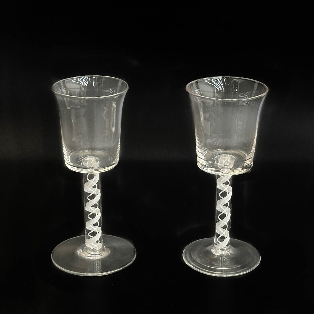 Pair English Air Twist Glass Wine Glasses 18th century: Pair English Air Twist Glasses, likely 18th century with a rough pontil and pronounced striations. White air twist decoration to the stem. Weight: Approx. 1 lb Measurements: Approx. 3 inches diameter 