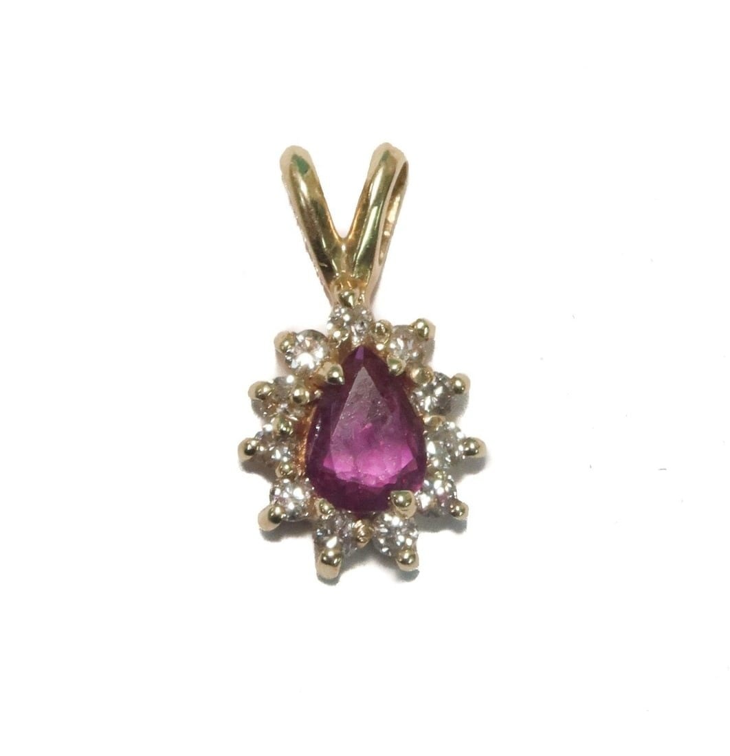 14k Yellow Gold Spinel and White Sapphire Necklace Pendant: 14k Yellow Gold Spinel and White Sapphire Necklace Pendant. Teardrop spinel to with round cut white sapphires to frame. Marked 14k to backing. Weight Approx., 1 gram Measures Approx., 0.5 inches x 0.5