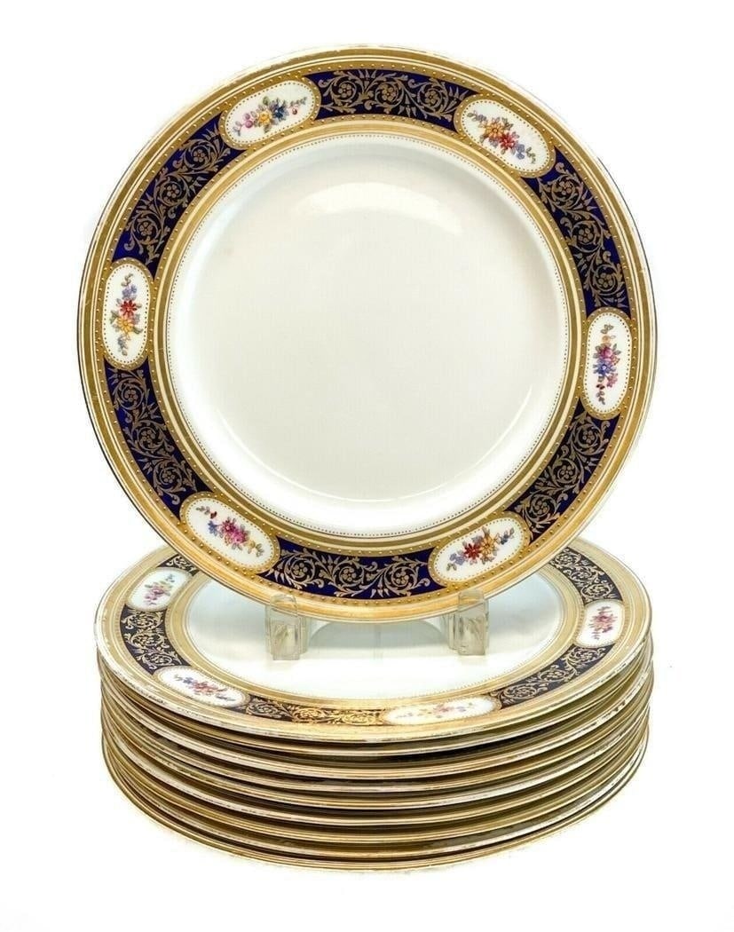 10 George Jones Crescent Porcelain Dinner Plates, c1910: 10 George Jones & Sons Crescent hand painted porcelain dinner plates, circa 1910 . A cobalt blue ground with hand painted flowers around the rim and gilt foliate scroll accents. Gilt beads throughout.