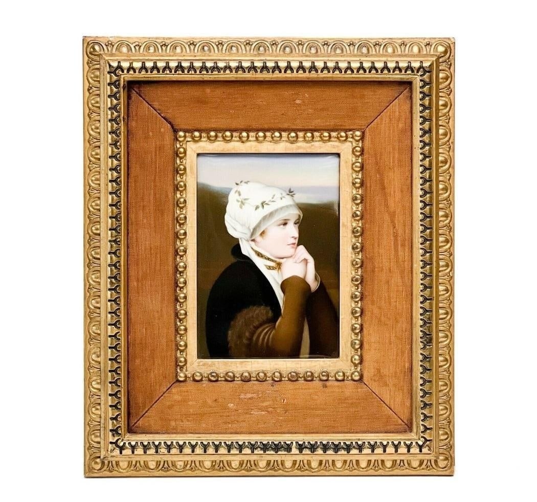 German Hand Painted Porcelain Plaque of a Woman: German hand painted porcelain plaque in period frame, early 20th century. Plaque depicts a hand painted image of a young woman in a landscape. In a gilt wood and fabric frame. Back of plaque impressed