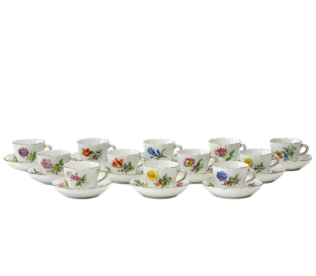 12 Meissen Demitasse Cups & Saucers Florals: 12 Meissen Germany hand painted floral demitasse cups & saucers. A white ground with various colorful floral decoration, each cup with a matching saucer. Gilt to the scalloped rim. Meissen crossed swo
