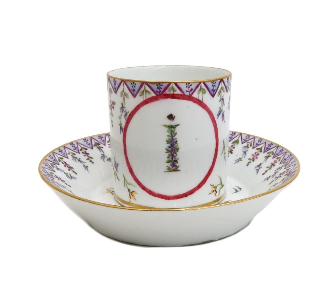 Sevres Porcelain Factory Hand Painted Floral and Gilt Cup and Saucer 1786: Sevres Porcelain Factory hand painted floral and gilt cup and saucer, 1786. Hand painted purple and blue floral sprigs throughout with gilt to rims. Sevres Porcelain Factory mark to underside with JJ 