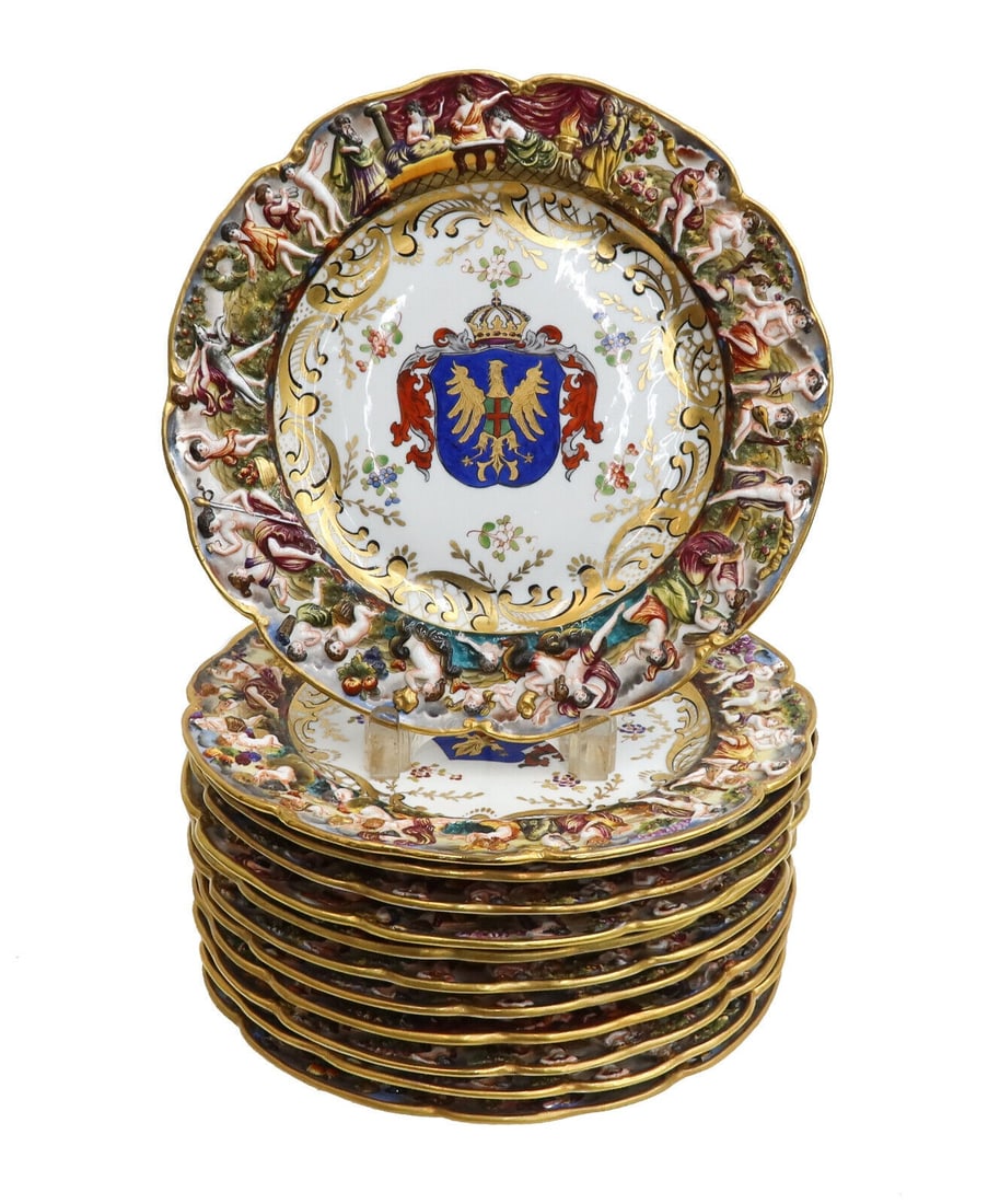 12 Capodimonte Porcelain 10.5 inch Armorial Plates circa 1940 Raised Figures: 12 Capodimonte porcelain 10.5 inch armorial plates circa 1940. Raised putti figures to rim with different armorial crests to cents. Capodimonte mark to underside. Weight: Approx. 12 lbs Measurements: