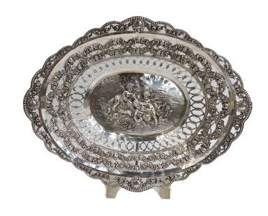 German 800 Silver Pierced Scallop Rimmed Putti Basket circa 1900: German 800 silver pierced scalloped tray, circa 1900. Repousse putti scene to center with floral swag garlands to rim. 800 German silver marks. Weight Approx. 14.75 ozt Measurements: Approx. 13.5 inch