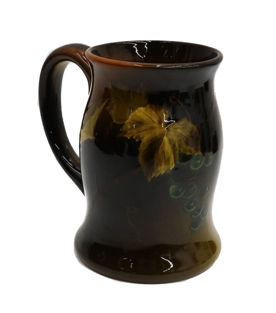 Rookwood Glazed Pottery Mug #761 by Lenore Asbury 1895: Rookwood glazed pottery mug #761 by Lenore Ashbury 1895. A brown and orange ground with grapes and leaves to central area. Rookwood glazed pottery marks to underside with artist initials for Lenore As